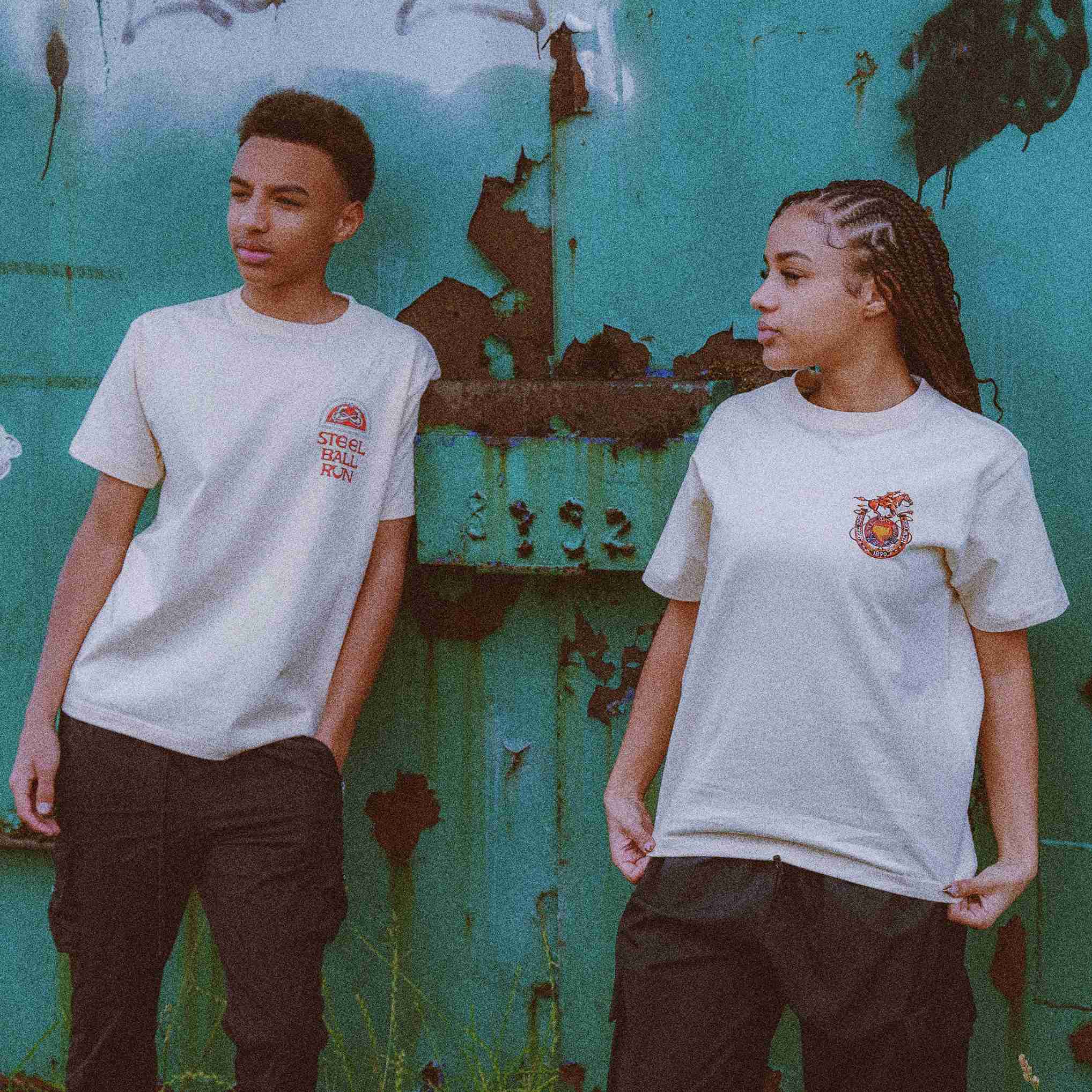 Two models wearing Jojo's Bizarre Adventure-themed t-shirts with iconic symbols from the series