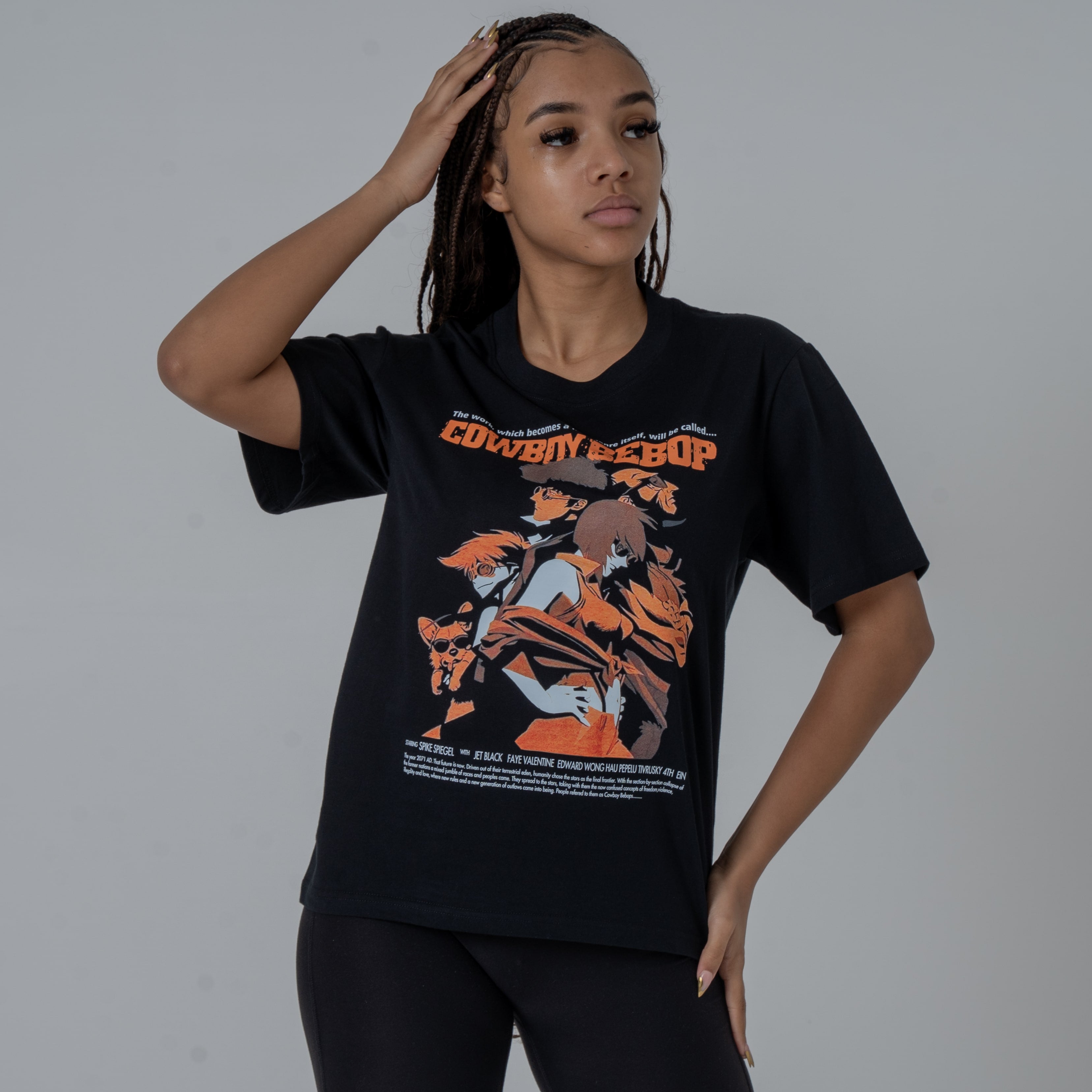 Front view of a female model in a studio wearing a black anime T-shirt featuring an orange Cowboy Bebop graphic with the main characters Spike Spiegel, Faye Valentine, Jet Black, Edward, and Ein.