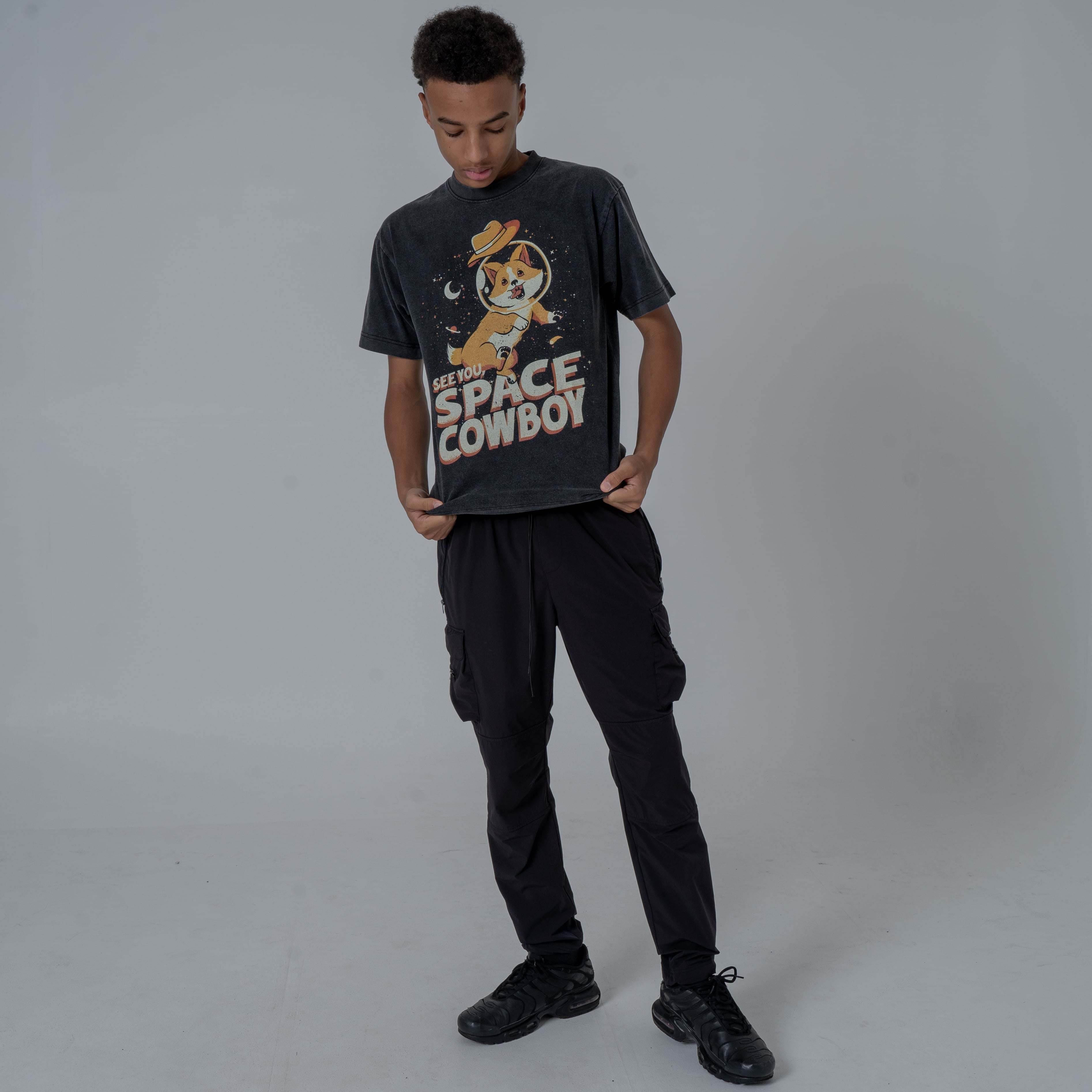 Full Body Shot of a Male Model looking down Wearing Black Vintage Washed Shirt Featuring Ein From Cowboy Bebop Anime with See You Space Cowboy Text.