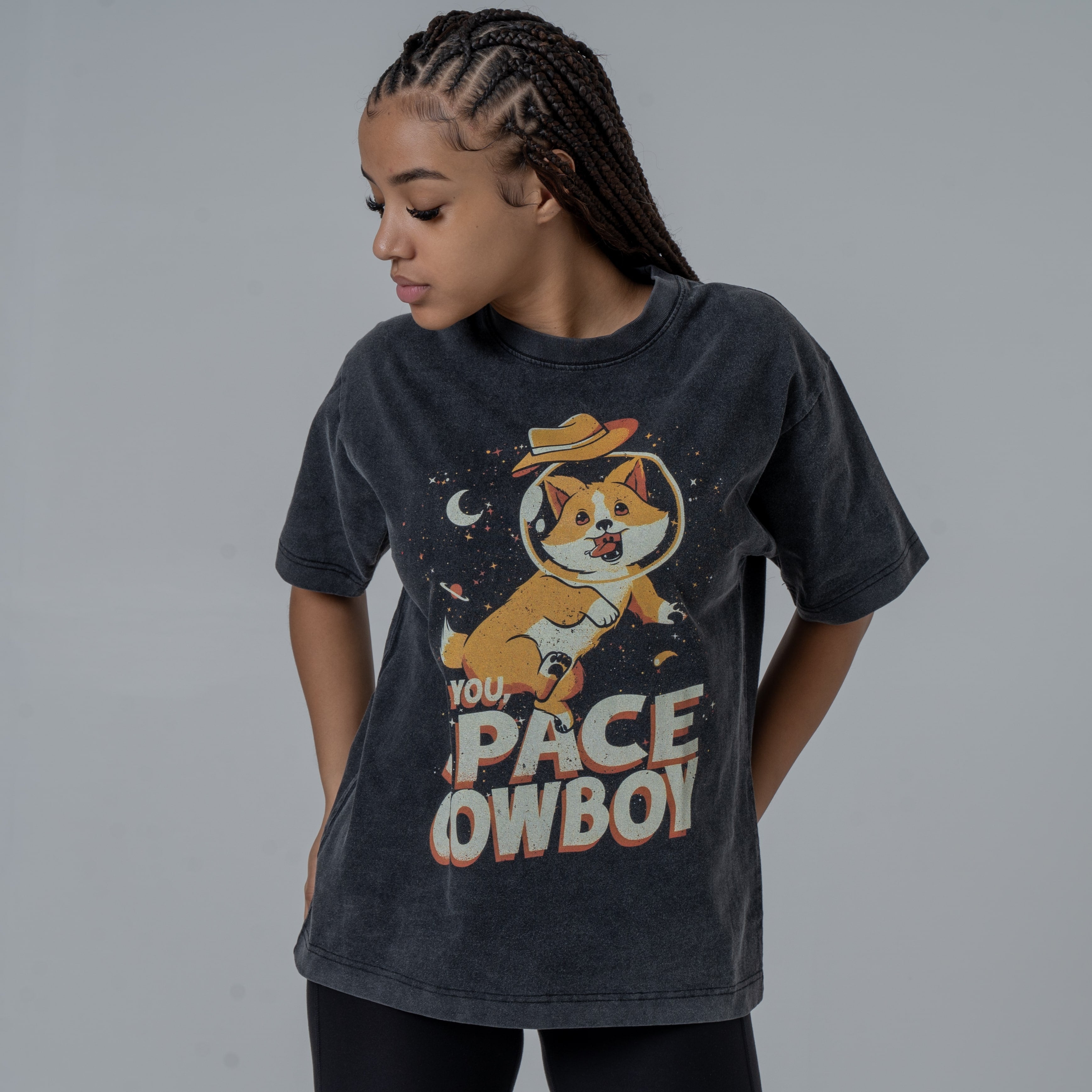 Model in a studio looking down left wearing black vintage washed T-Shirt featruing colorful graphic of Ein from CowBoy Bebop with See You Space Cowboy text.